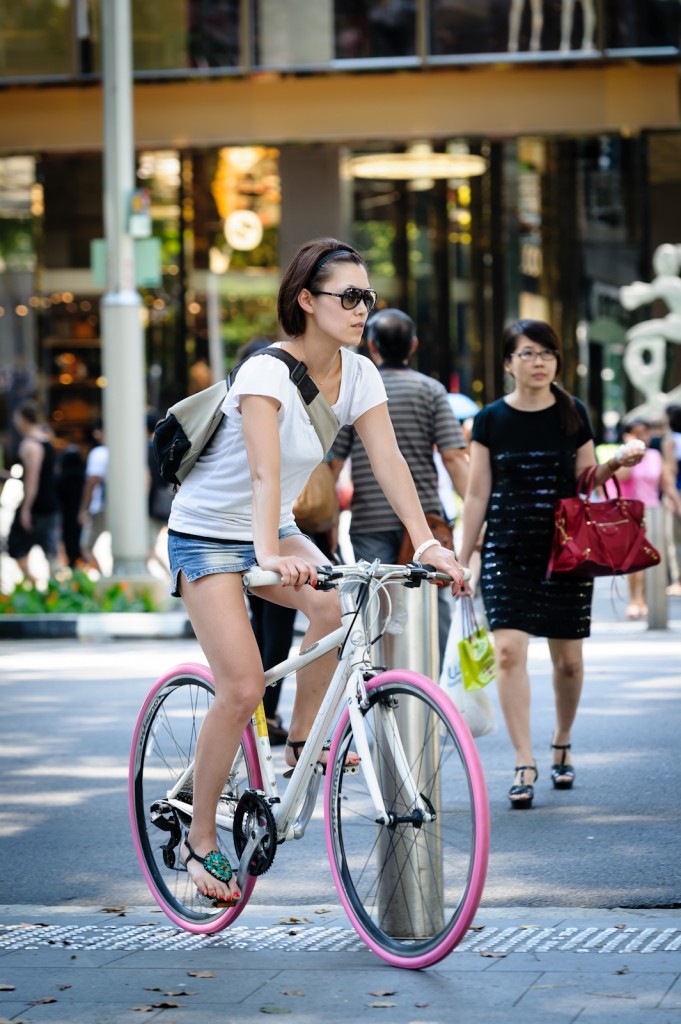 Street photography - Girl riding a bicycle with pink tyres in Orchard Singapore