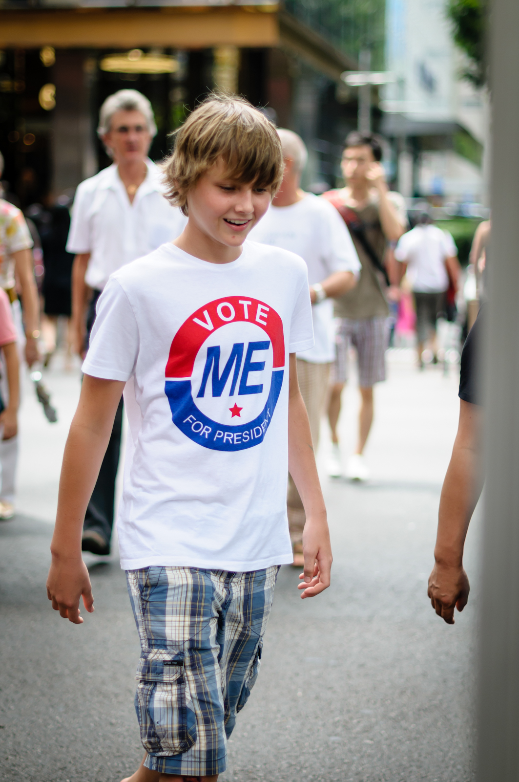 Street photography - boy wearing t-shirt that says vote me for president