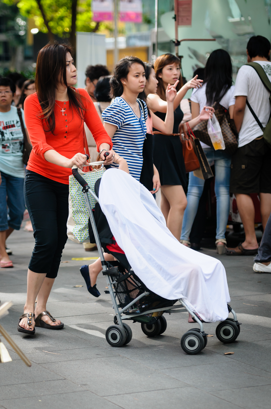 Street photography - Mother pushing a pram draped with a white cloth