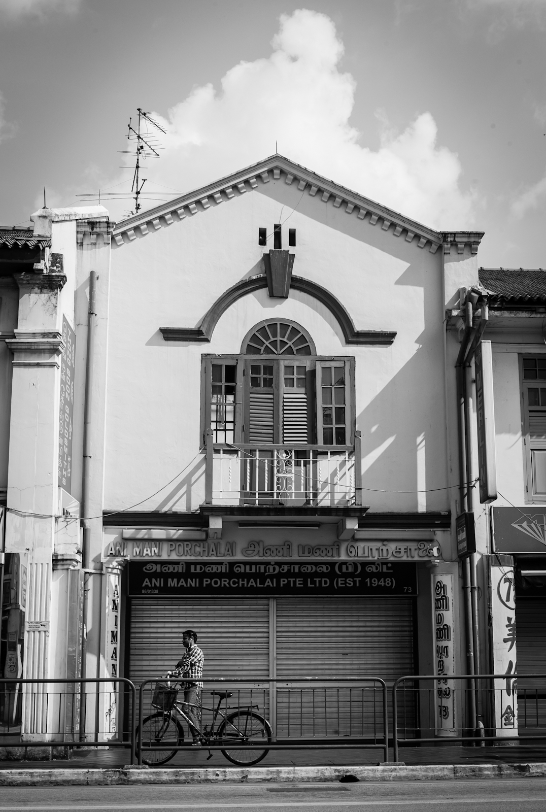 Street photography - Man pushing his bicycle past a shop house in Little India
