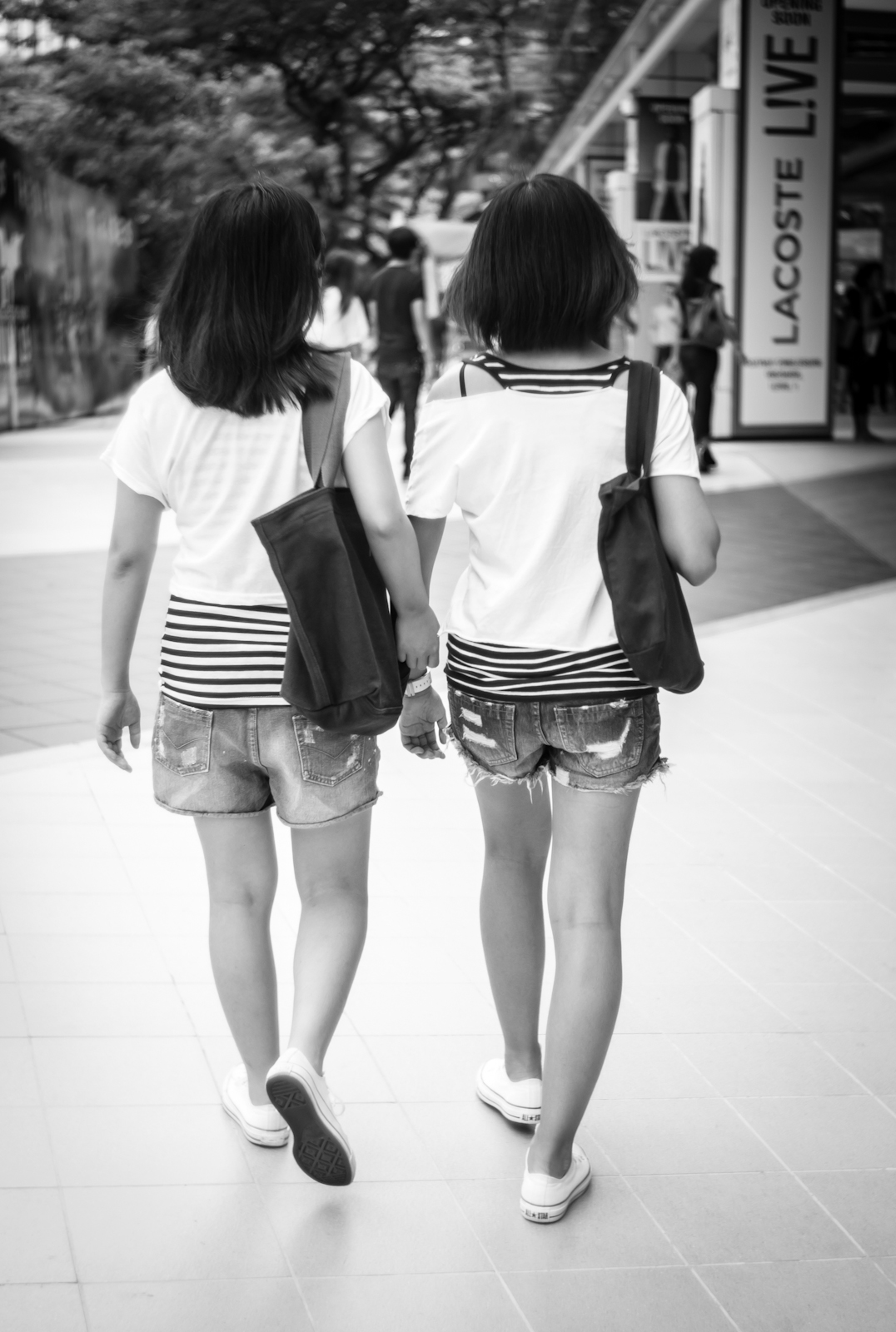 Two girls in almost identical clothing, shoes and bags