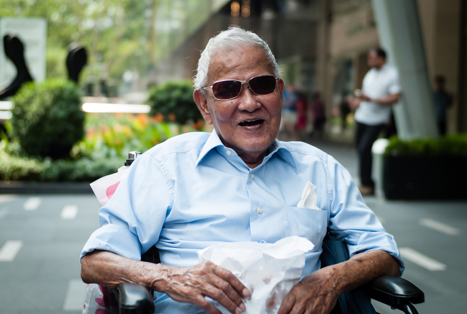 Elderly man wearing sunglasses and sitting in a wheel chair